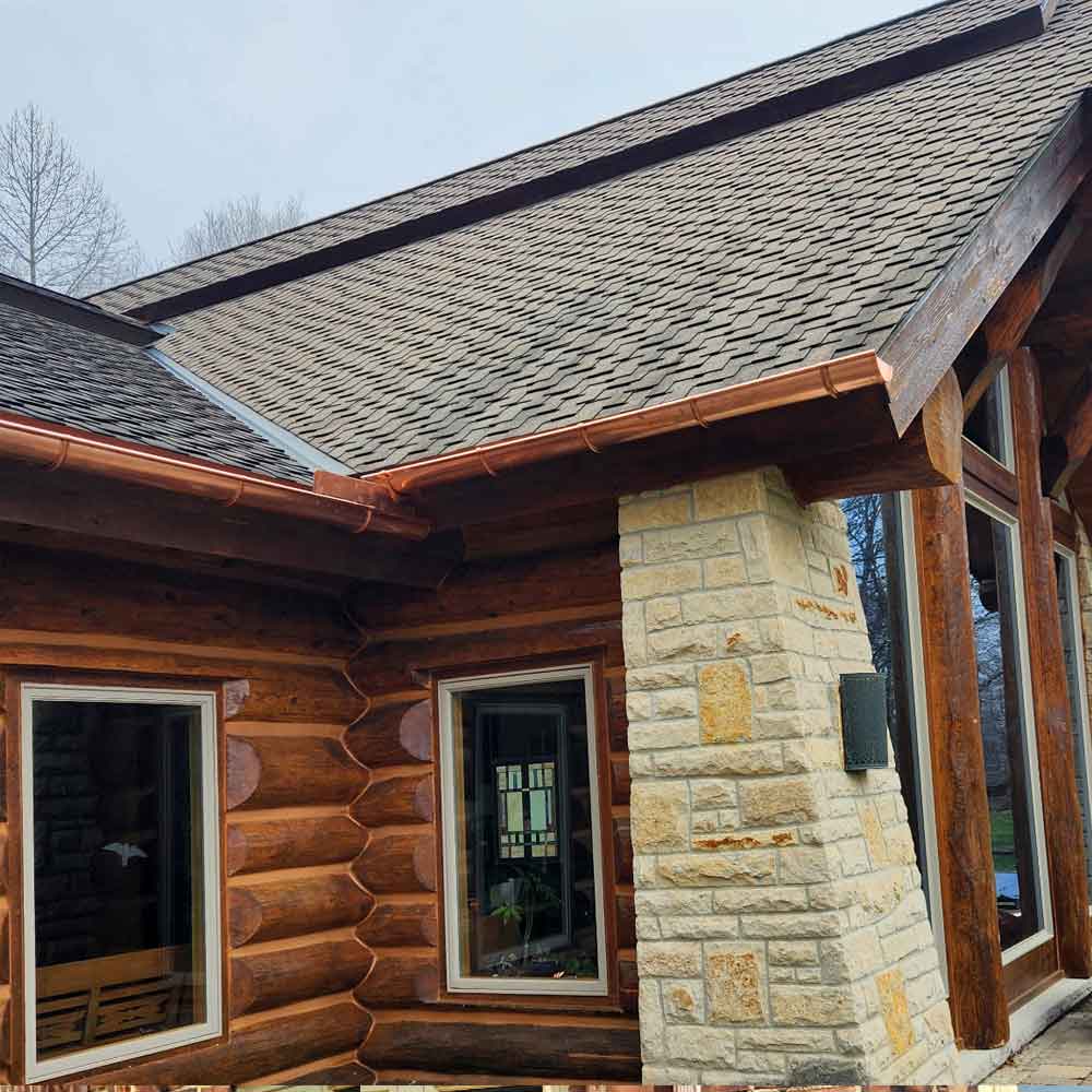 copper half-round gutter installed on log cabin home